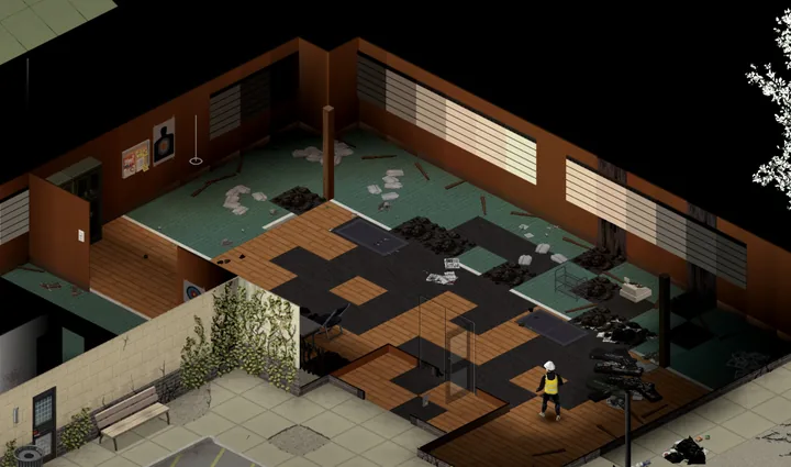 A game screenshot inside a burned-out gun shop: brown walls with empty slatwall displays and a paper shooting target, the floor burned through to black in patches with charred boards and heaps of ash, and a survivor in a white hard hat and hi-vis vest standing in the wreckage.